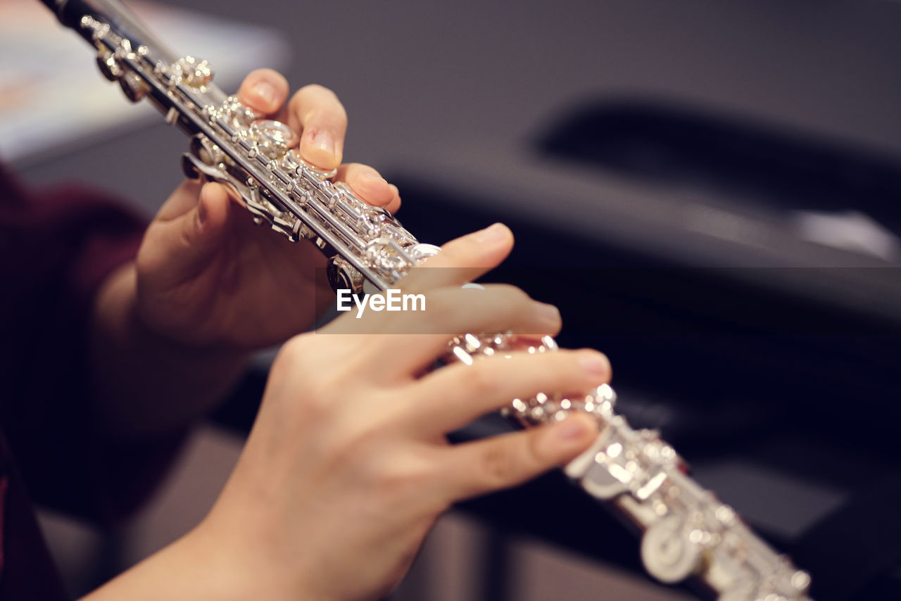 Cropped image of hands holding flute