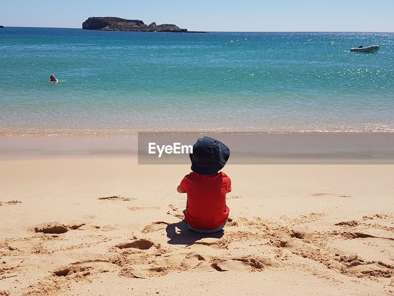 Rear view of boy on shore at beach