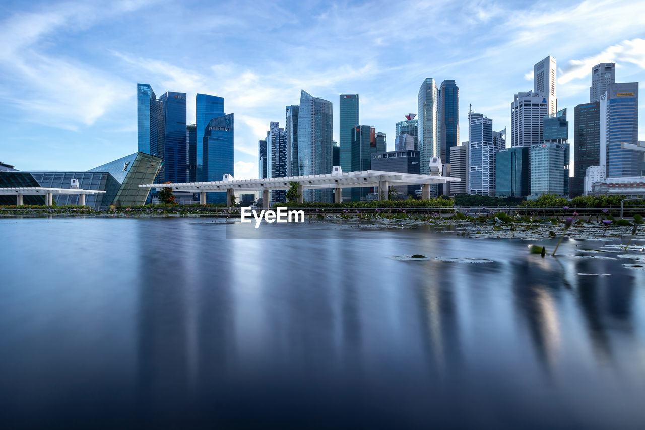 Business buildings around marina bay in singapore with smooth reflection on water surface
