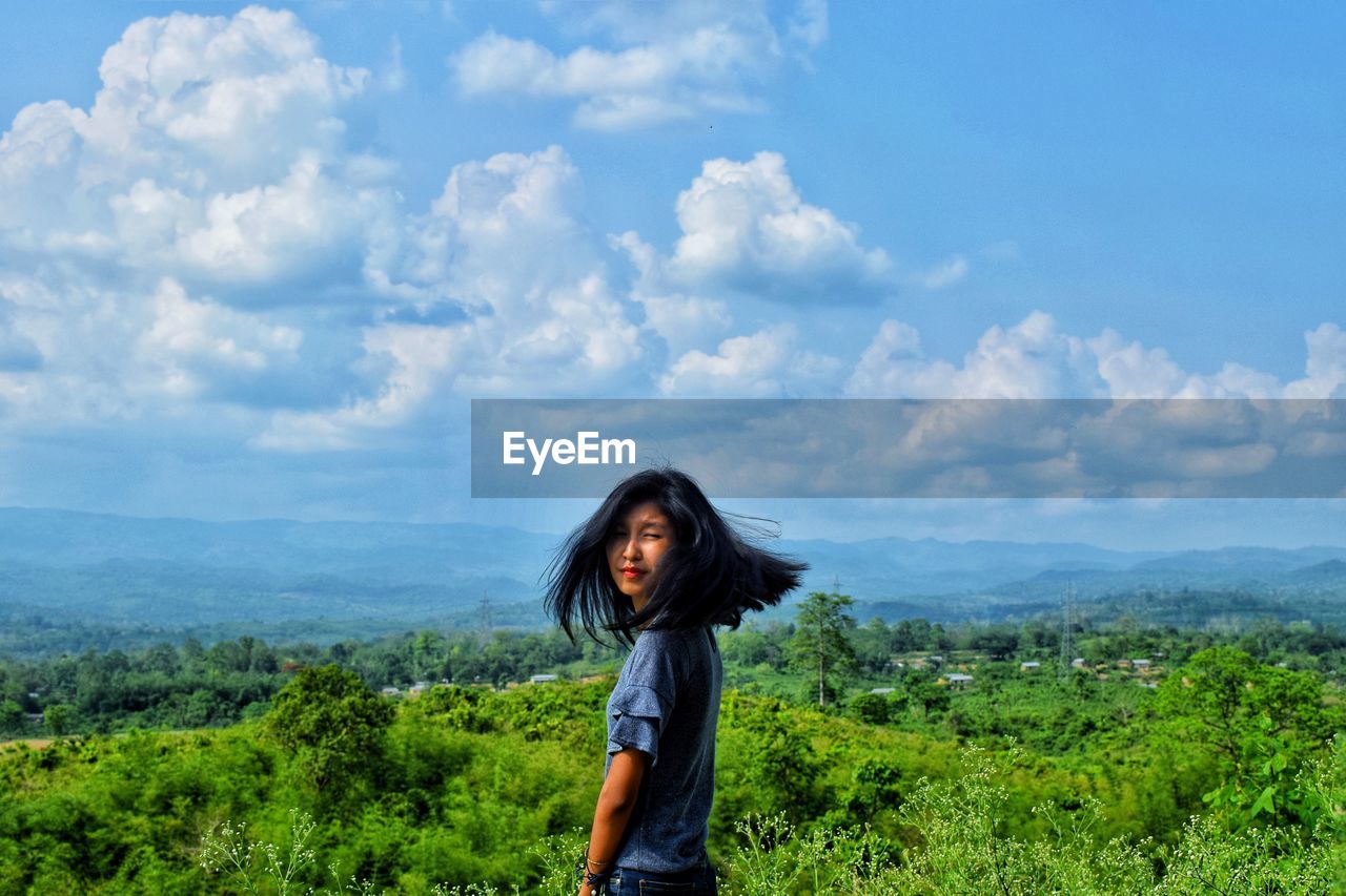 Woman standing by plants against sky