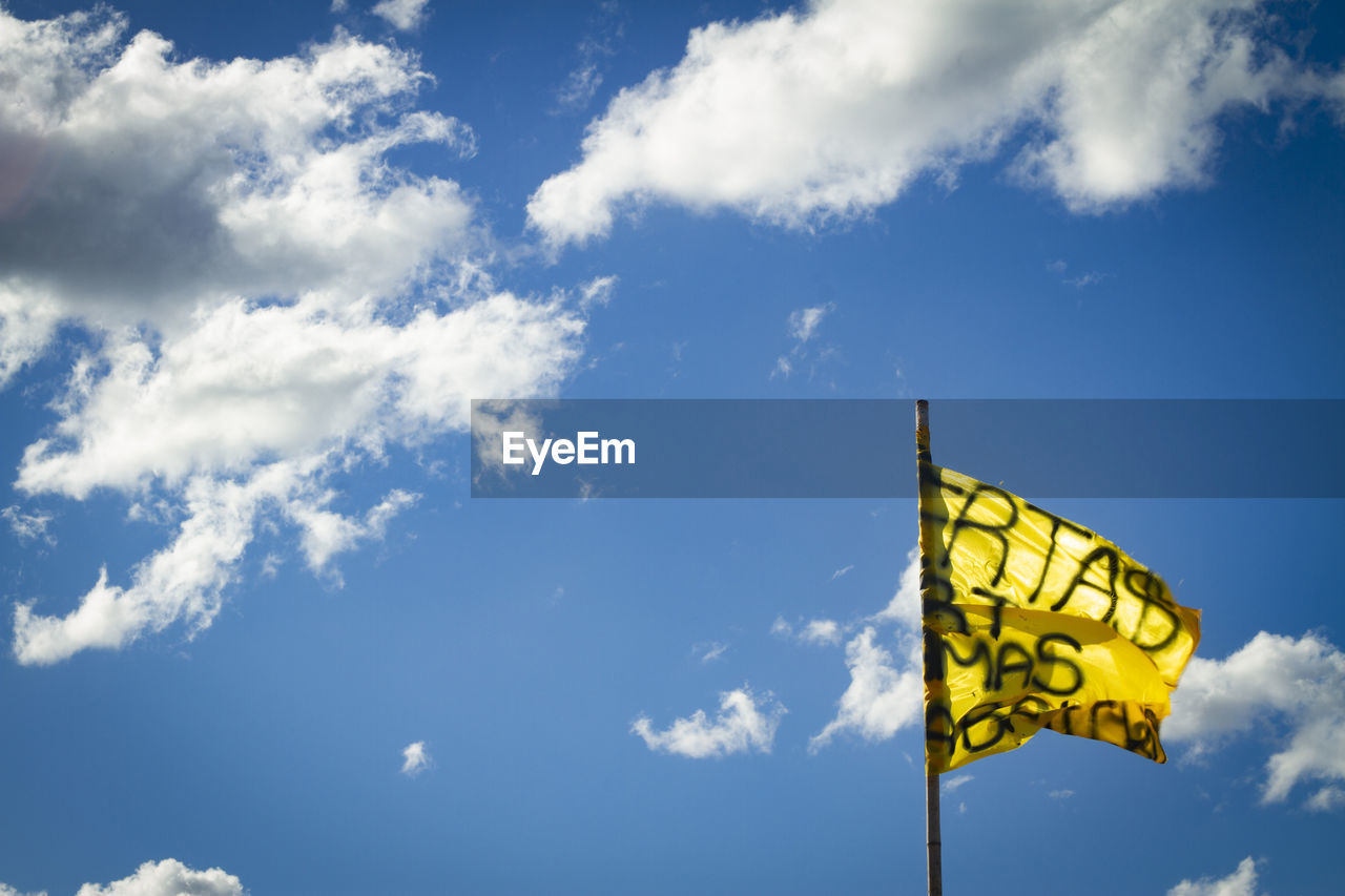 LOW ANGLE VIEW OF YELLOW SIGN AGAINST SKY