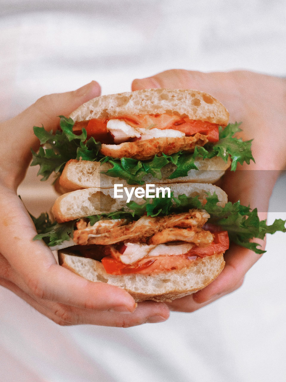 CLOSE-UP OF HAND HOLDING SANDWICH