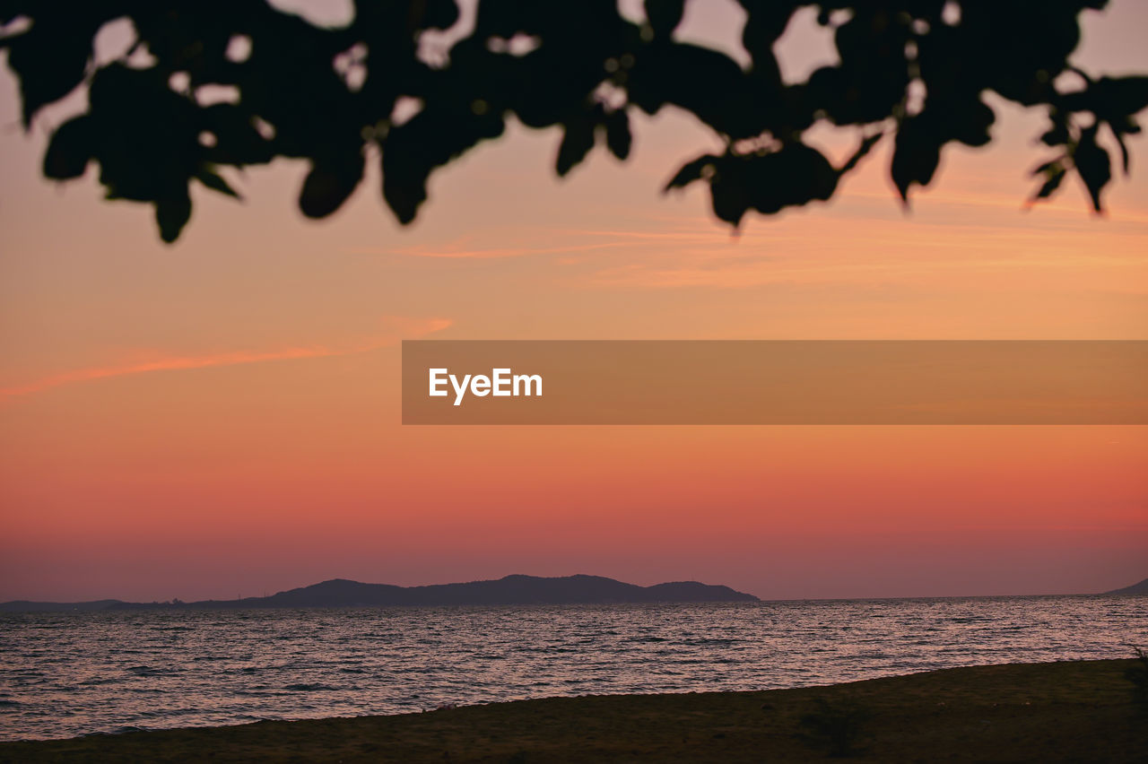 sunset, sky, sea, water, beauty in nature, scenics - nature, nature, land, tranquility, silhouette, beach, orange color, evening, tranquil scene, dawn, tree, horizon, no people, afterglow, cloud, idyllic, sunlight, environment, horizon over water, sun, outdoors, dramatic sky, plant, travel destinations, landscape, ocean, mountain, reflection, seascape, travel, tropical climate