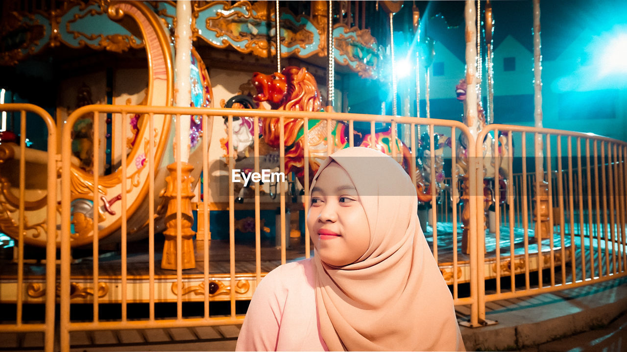 Portrait of woman in amusement park at night