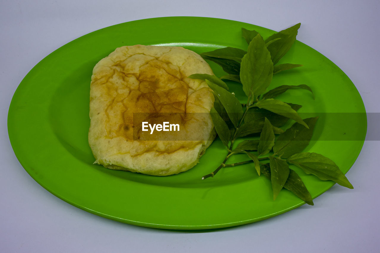 HIGH ANGLE VIEW OF FOOD IN PLATE ON GREEN BACKGROUND