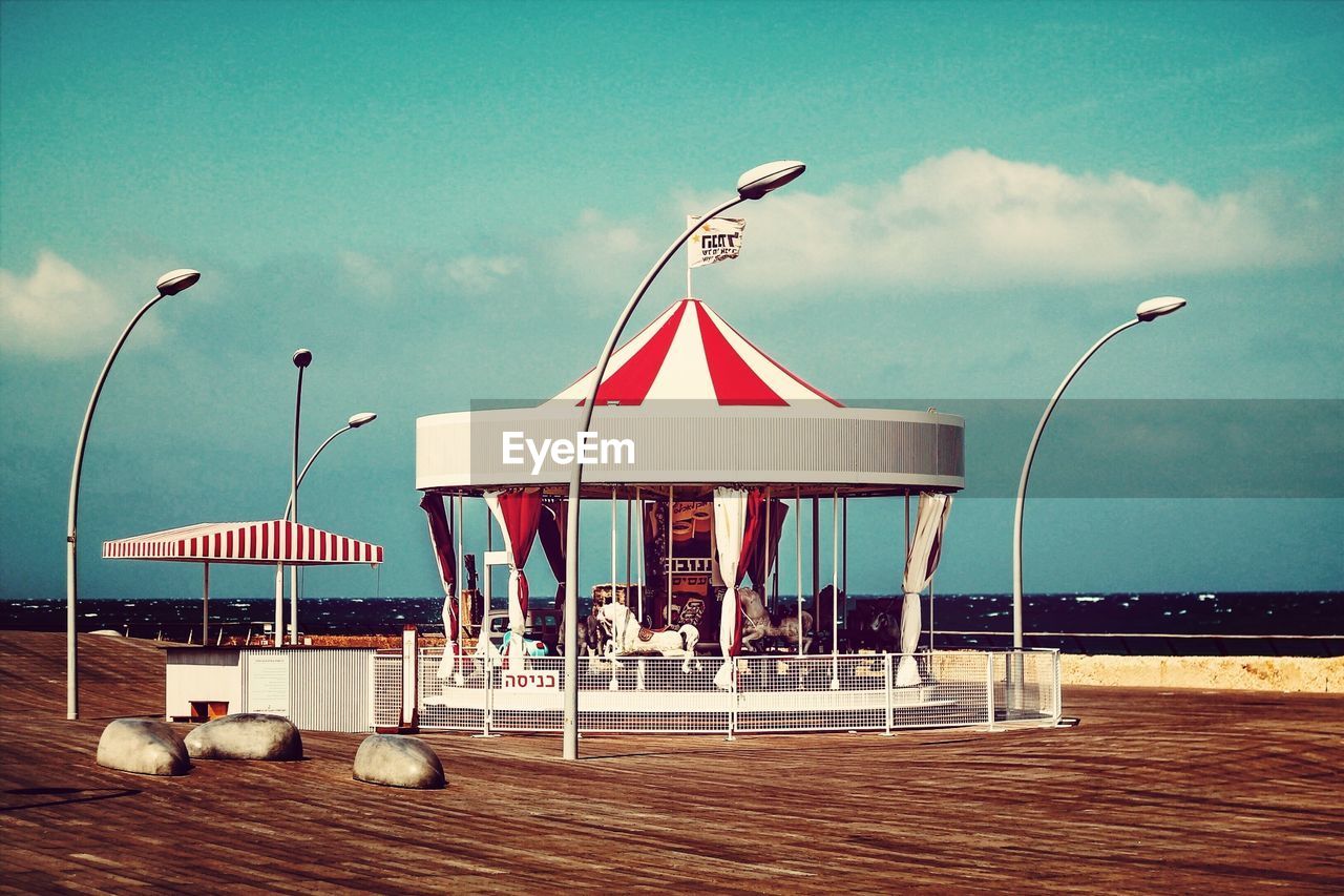 View of carousel at beach against sky