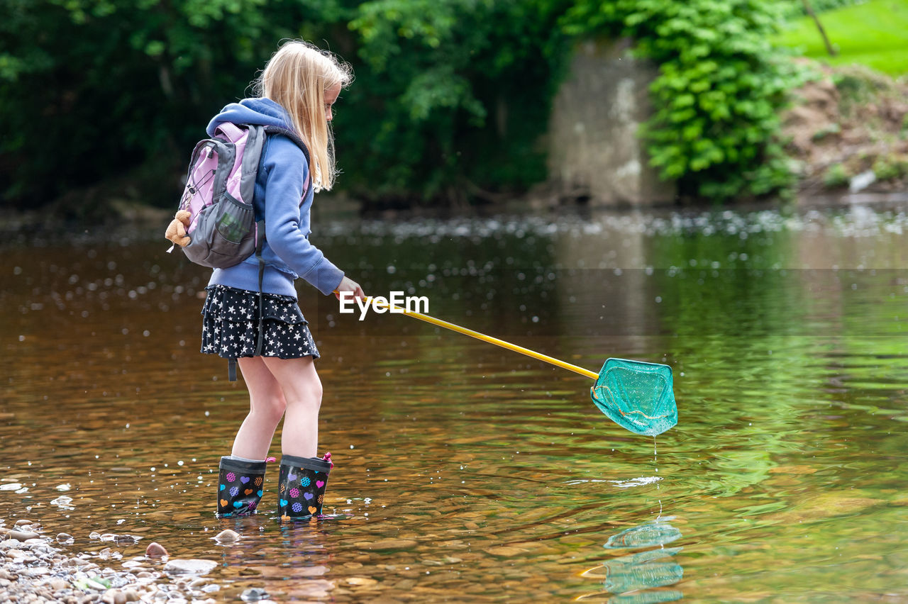 Girl standing against lake