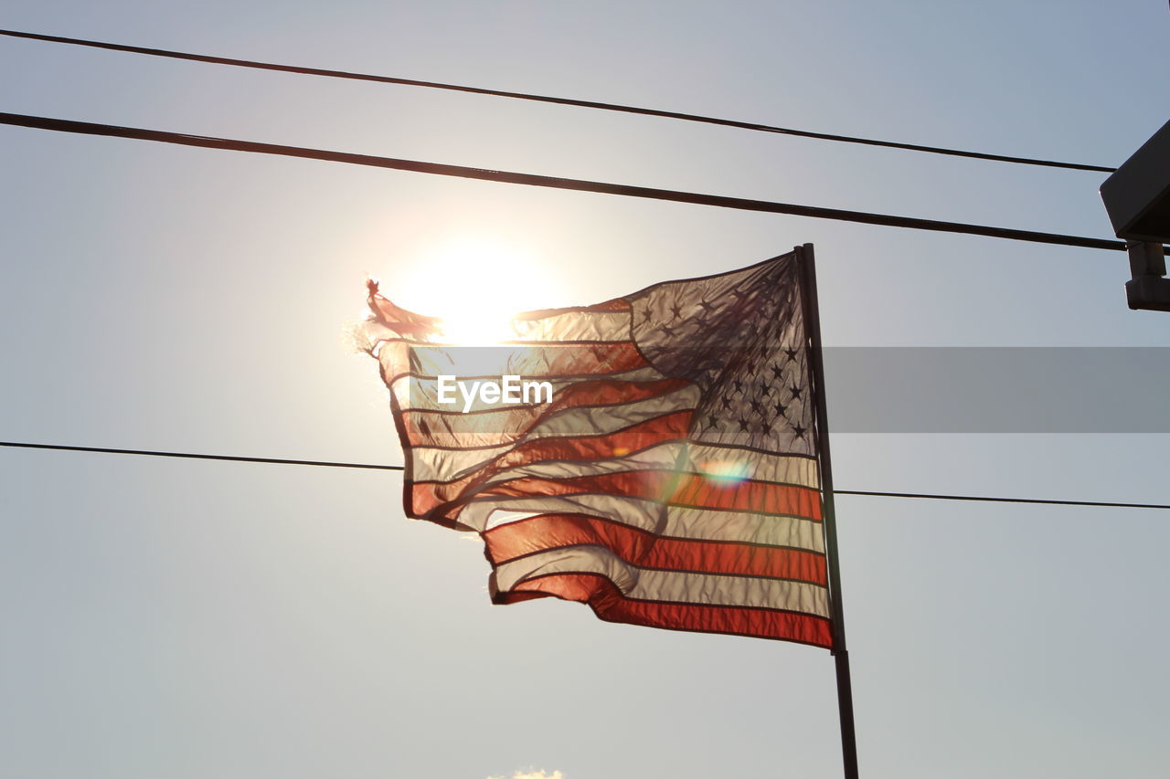 Low angle view of flags against sky at sunset