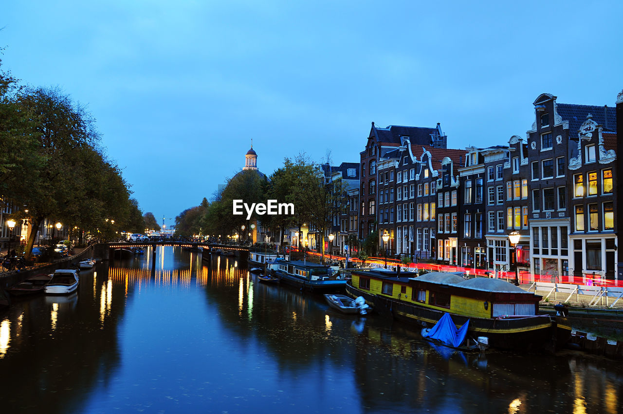 Boats moored in canal at dusk