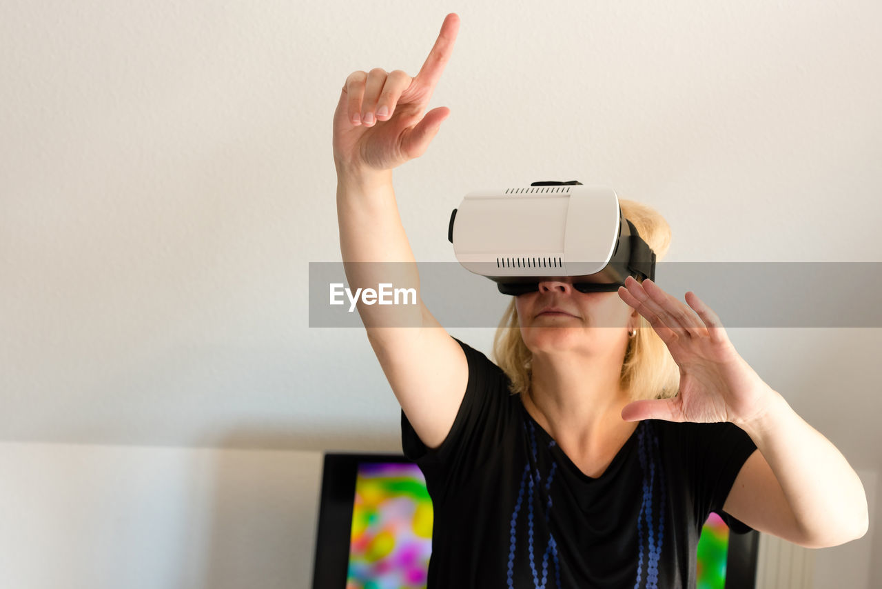 Middle-aged woman looking through virtual reality glasses