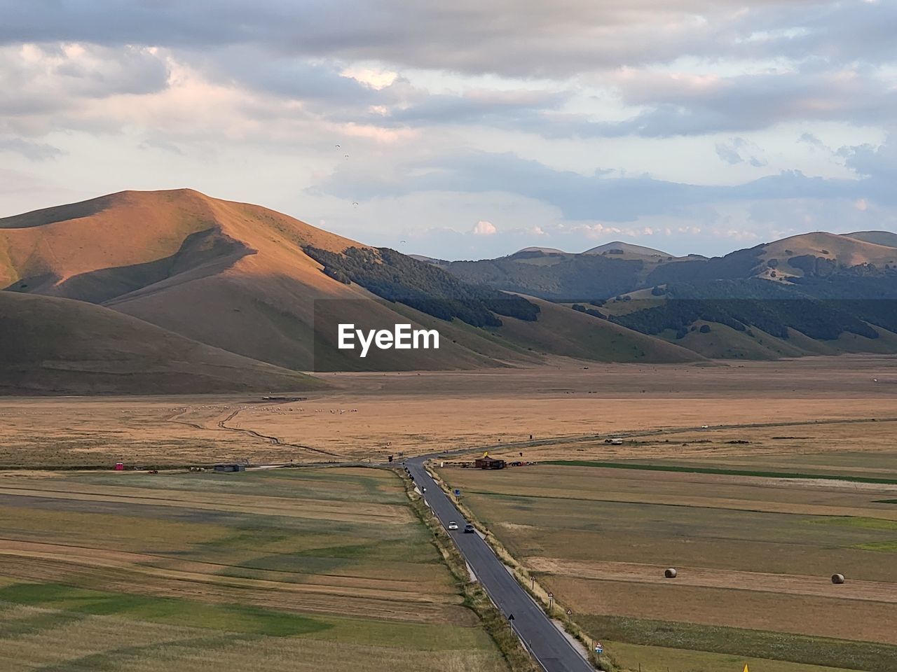 landscape, environment, scenics - nature, land, mountain, plain, sky, nature, beauty in nature, cloud, field, rural scene, mountain range, road, no people, travel, tranquility, agriculture, non-urban scene, travel destinations, tranquil scene, rural area, outdoors, plant, day, grass, horizon, steppe, prairie, transportation, tourism, valley, grassland, plateau, social issues, farm, semi-arid, remote, water, sunlight, natural environment