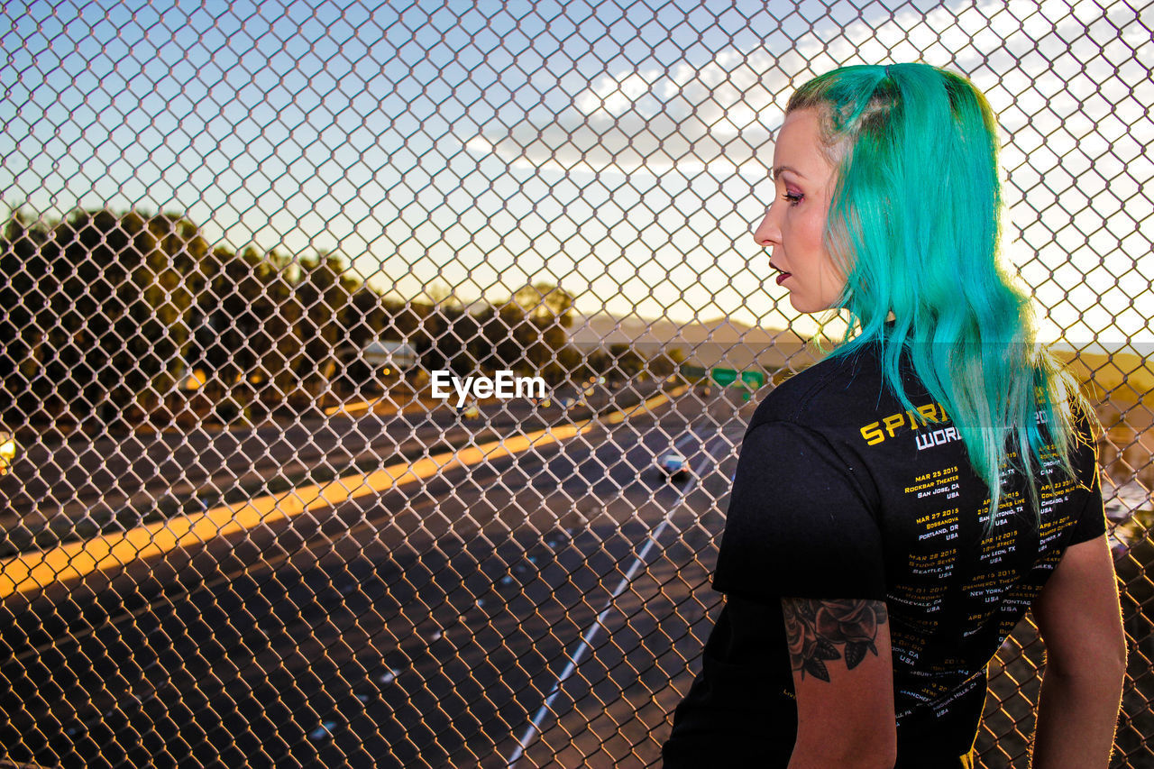 Woman standing next to chainlink fence