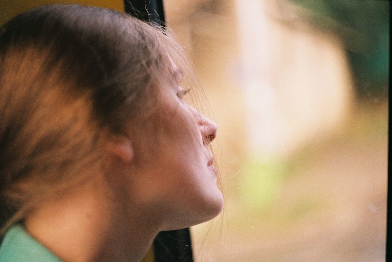 Close-up of woman looking through window