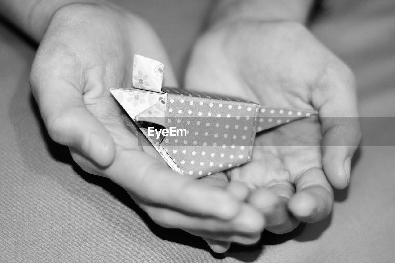 Cropped hands of woman holding paper craft