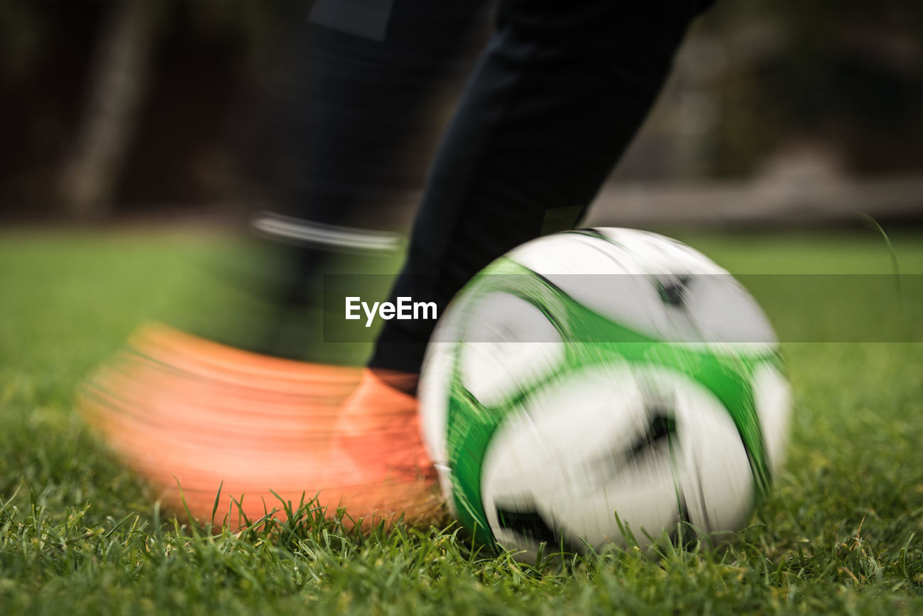 Low Section Of Person Kicking Soccer Ball On Id 95217311