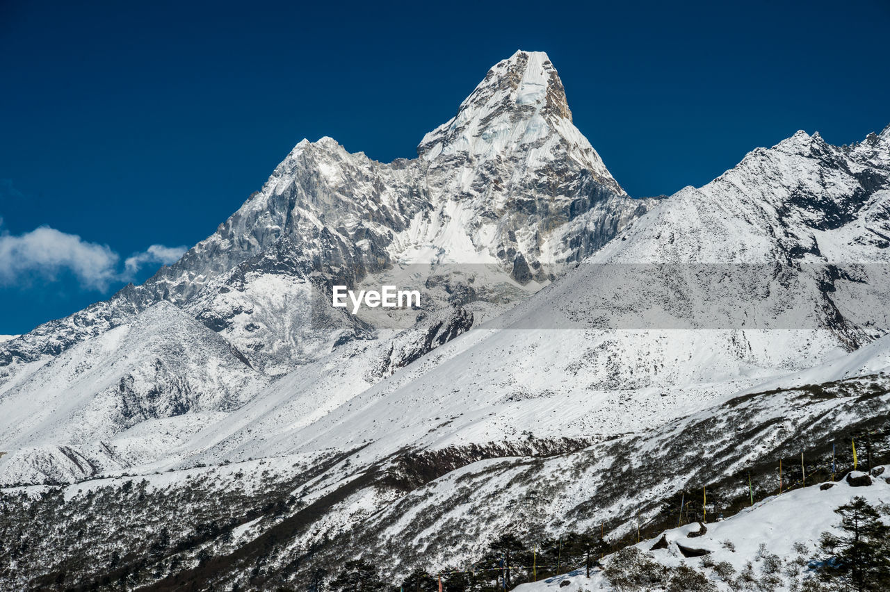 Scenic view of snowcapped mountains against clear blue sky
