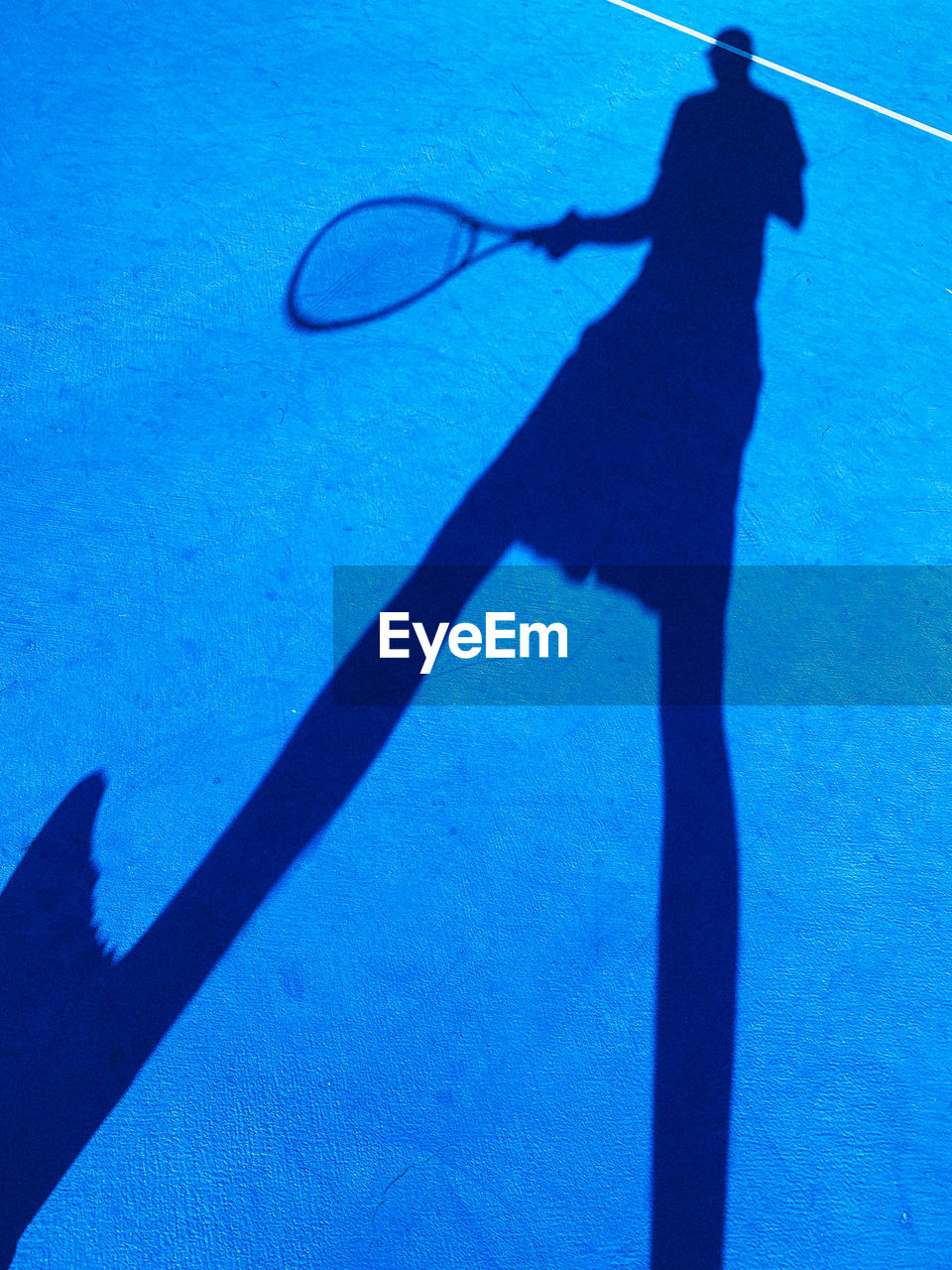 HIGH ANGLE VIEW OF SHADOW OF PERSON PLAYING IN THE BLUE