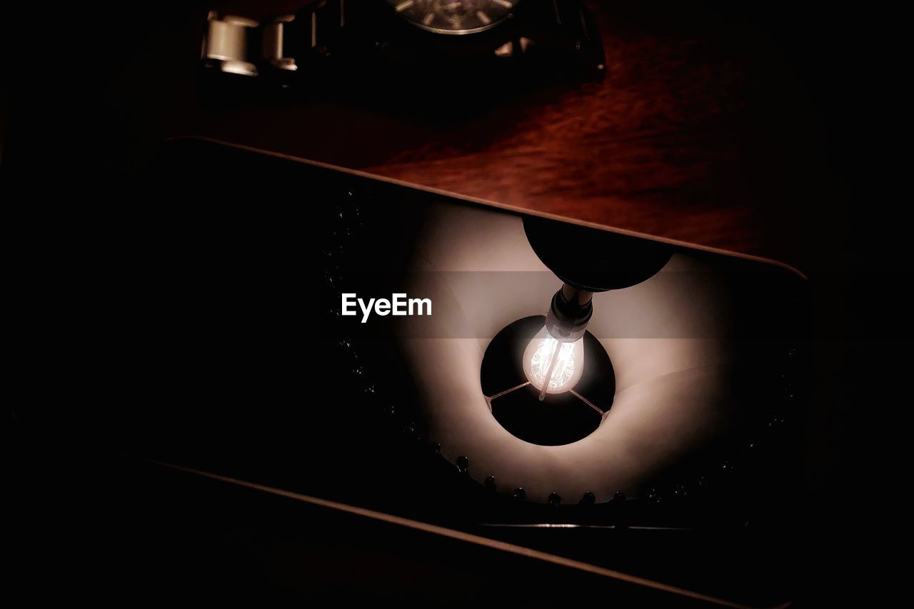 HIGH ANGLE VIEW OF ILLUMINATED LAMP IN DARK