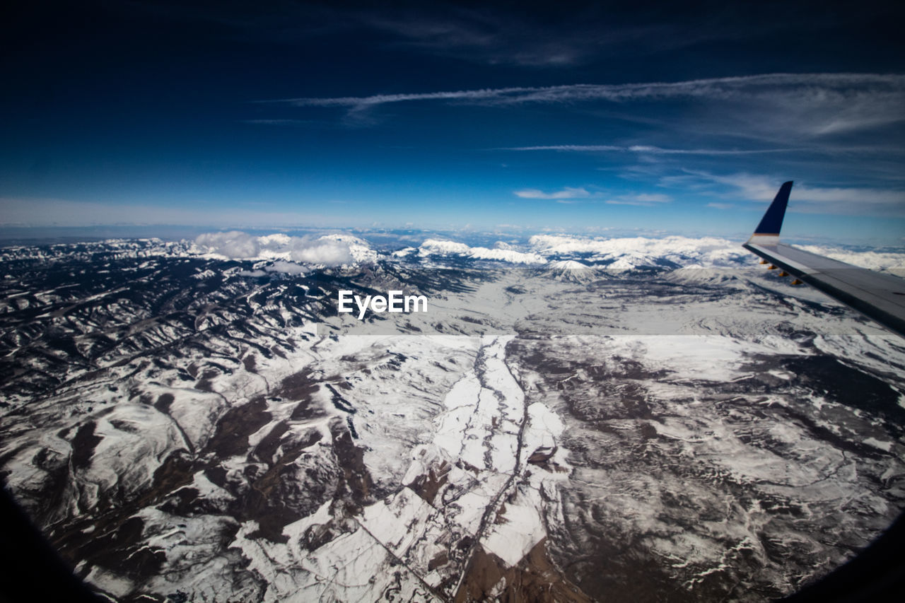 AERIAL VIEW OF SNOWCAPPED LANDSCAPE AGAINST SKY