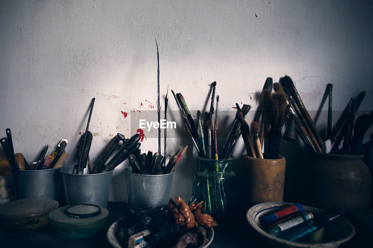 Paintbrushes on table against wall