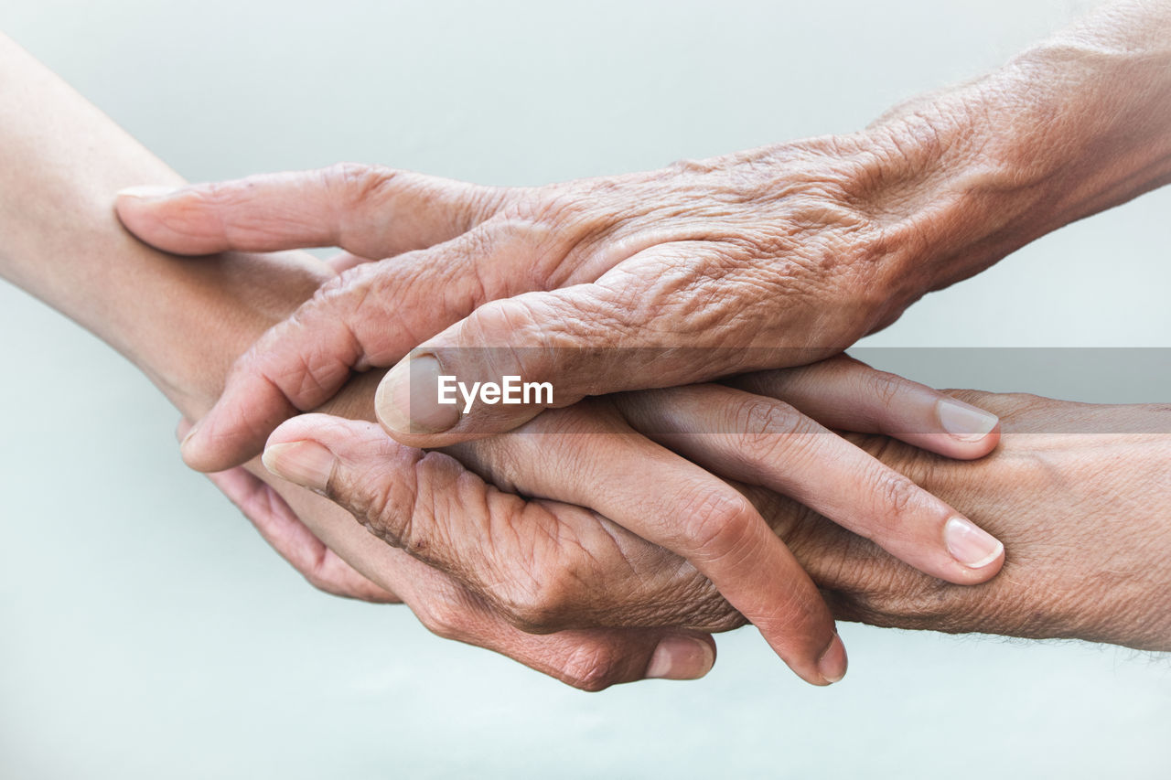 Cropped image of senior people stacking hands outdoors