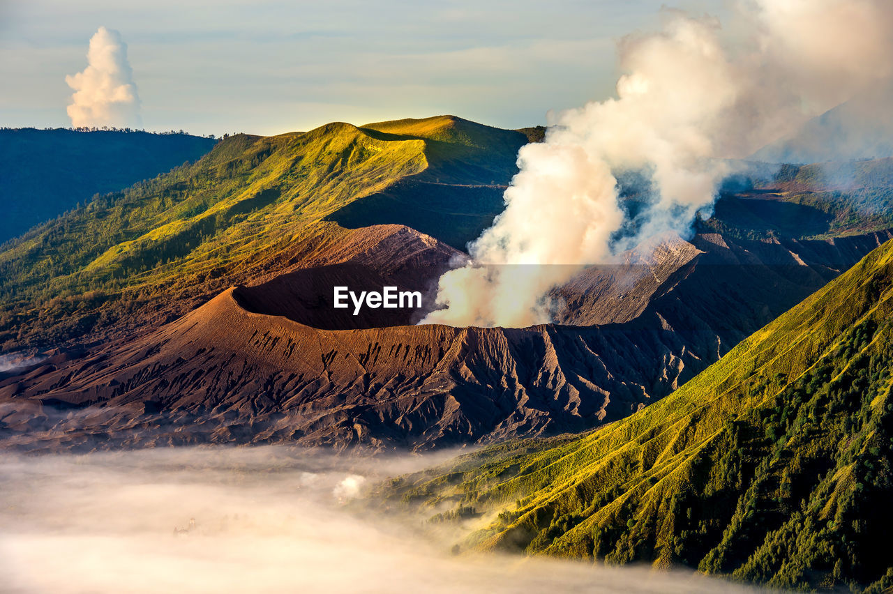 Active volcano at bromo crater against sky during sunrise