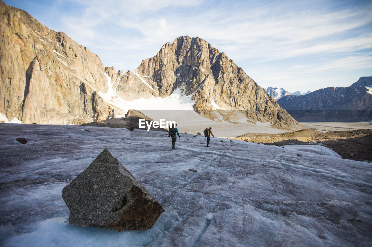 Rear view of two mountaineers crossing a mountain glacier.
