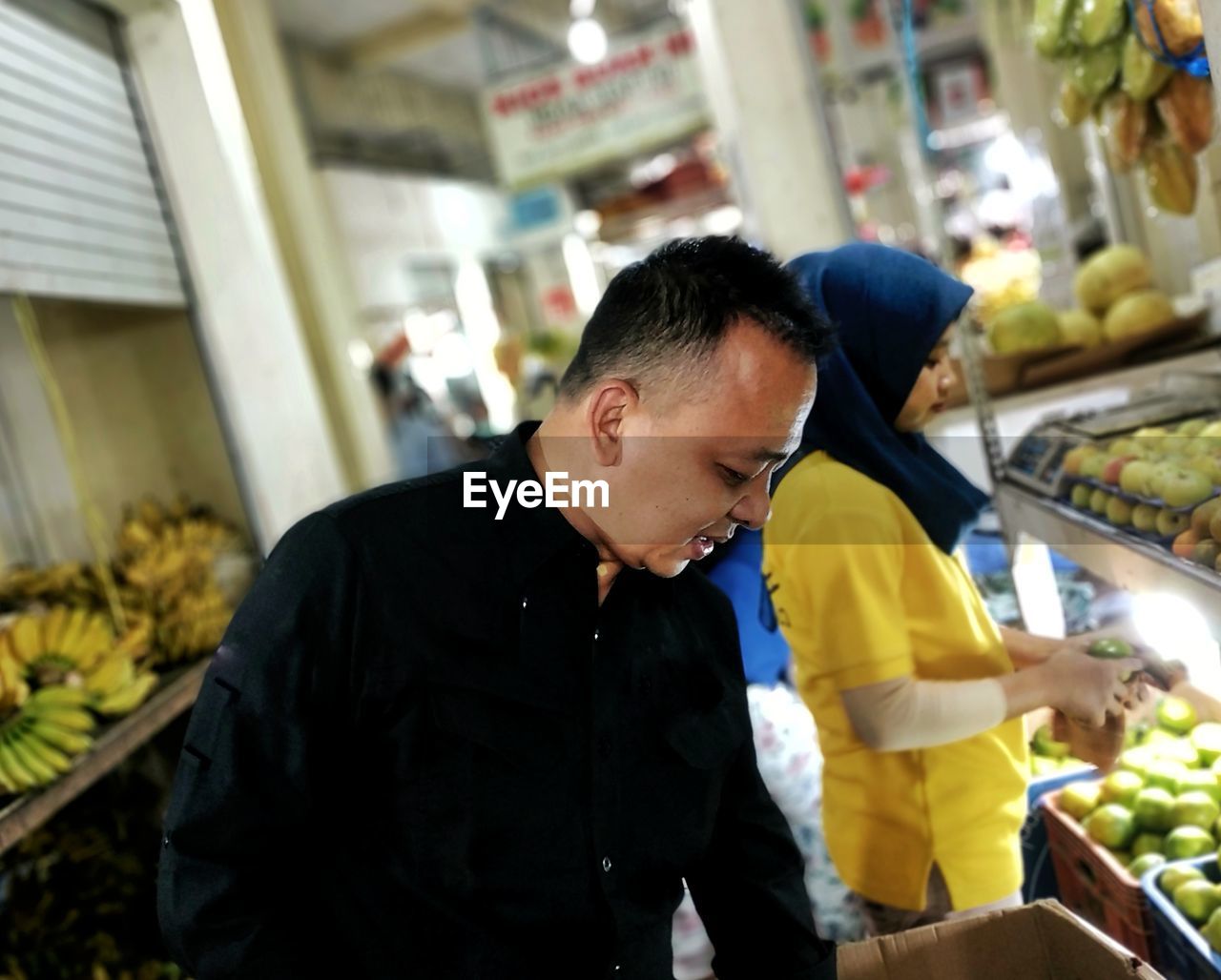 Mature man buying fruits in supermarket
