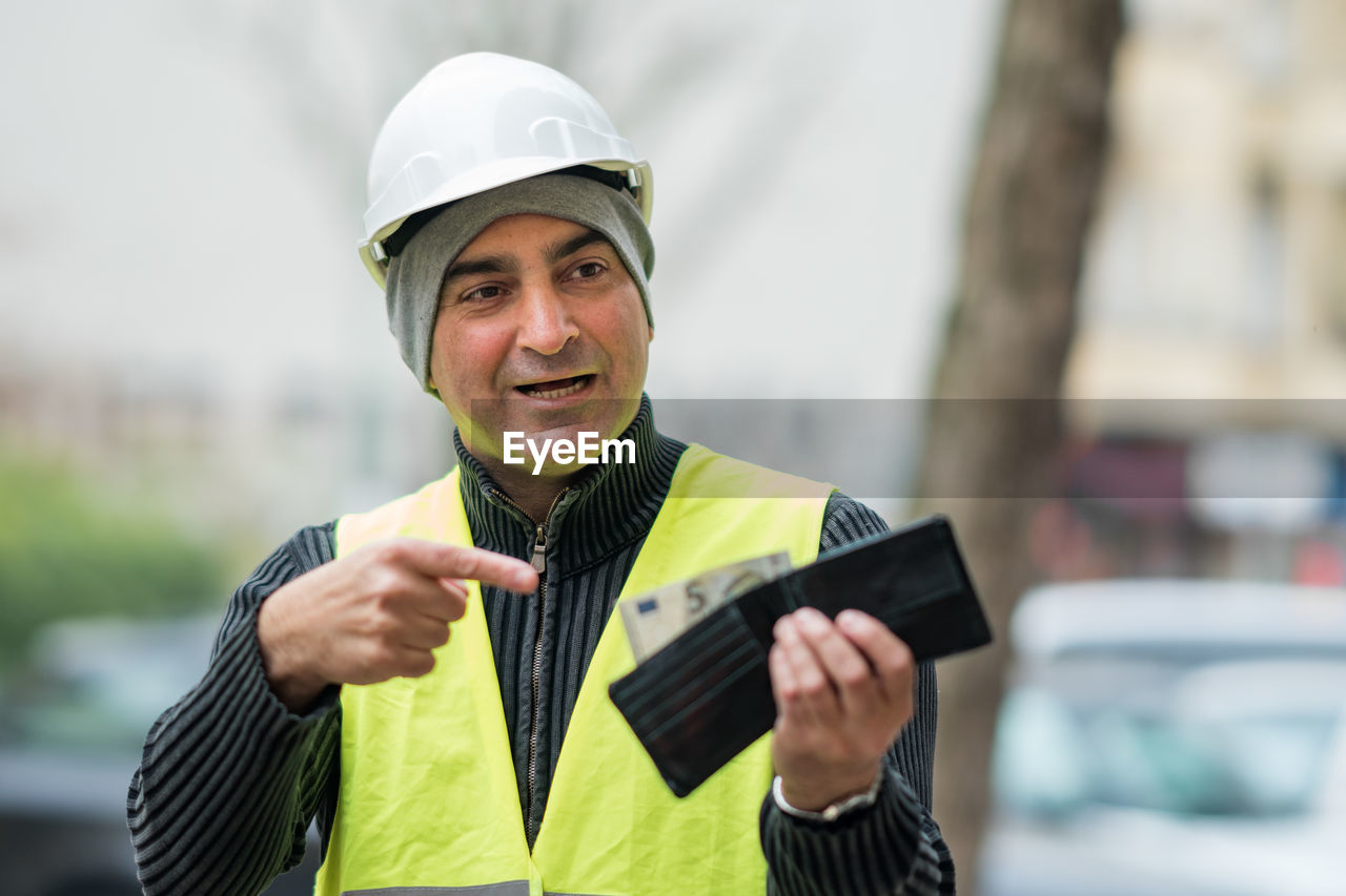 Engineer in reflective clothing looking at wallet