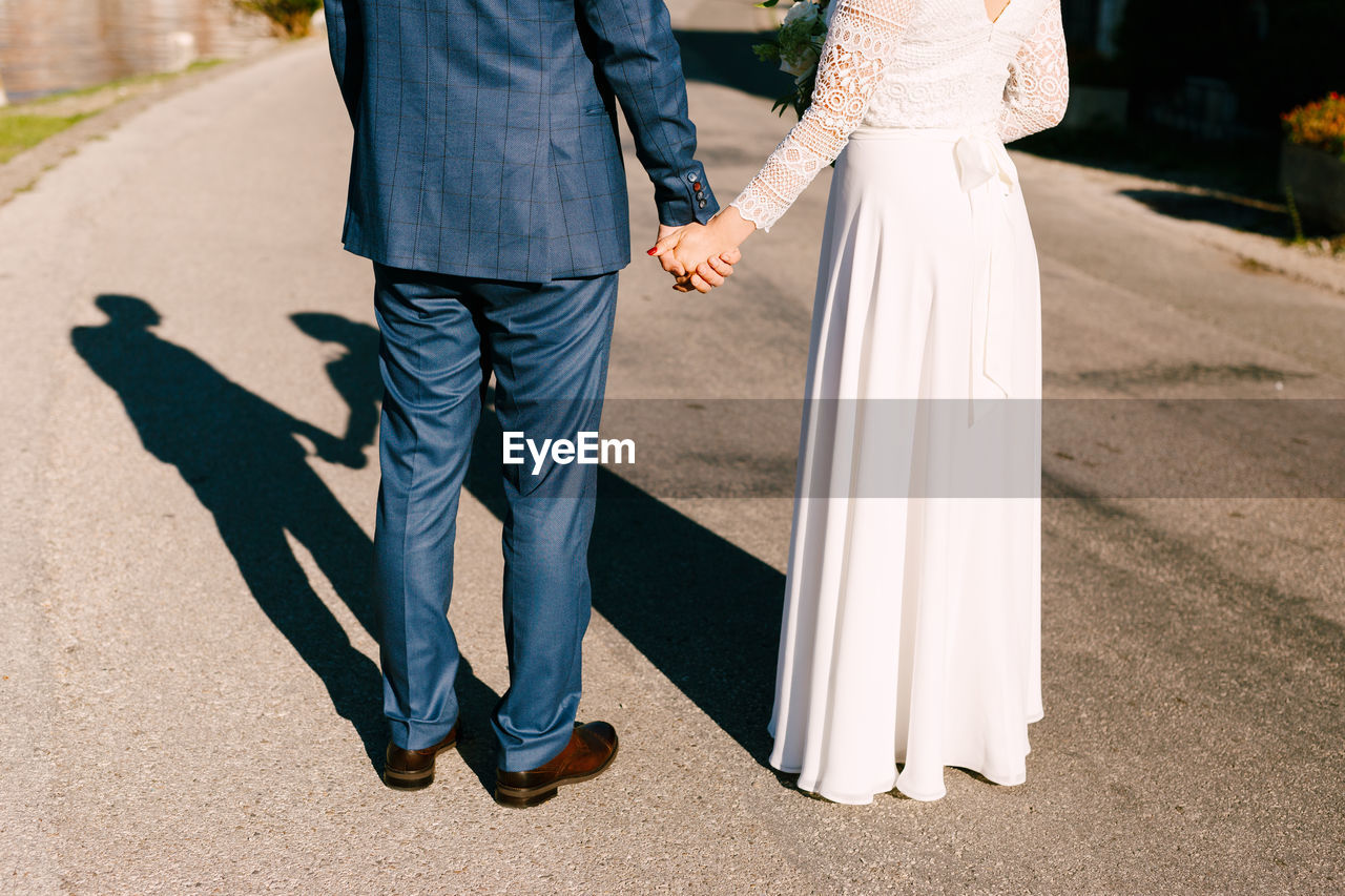 Low section of couple standing on road