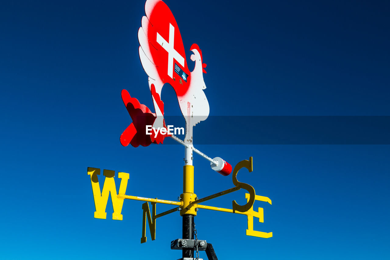 Low angle view of weather vane against blue sky.view from klein matterhorn, swiss alps