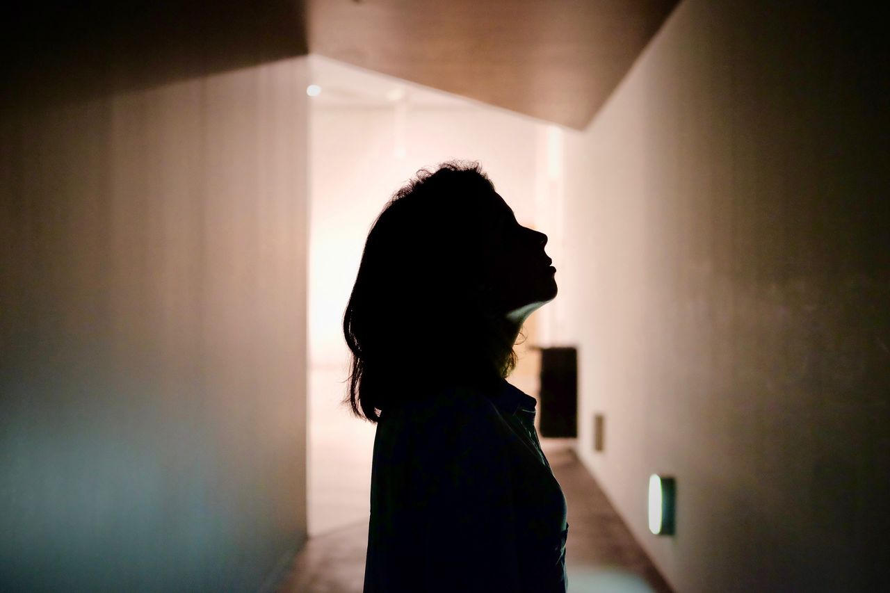 Side view of silhouette woman standing in museum