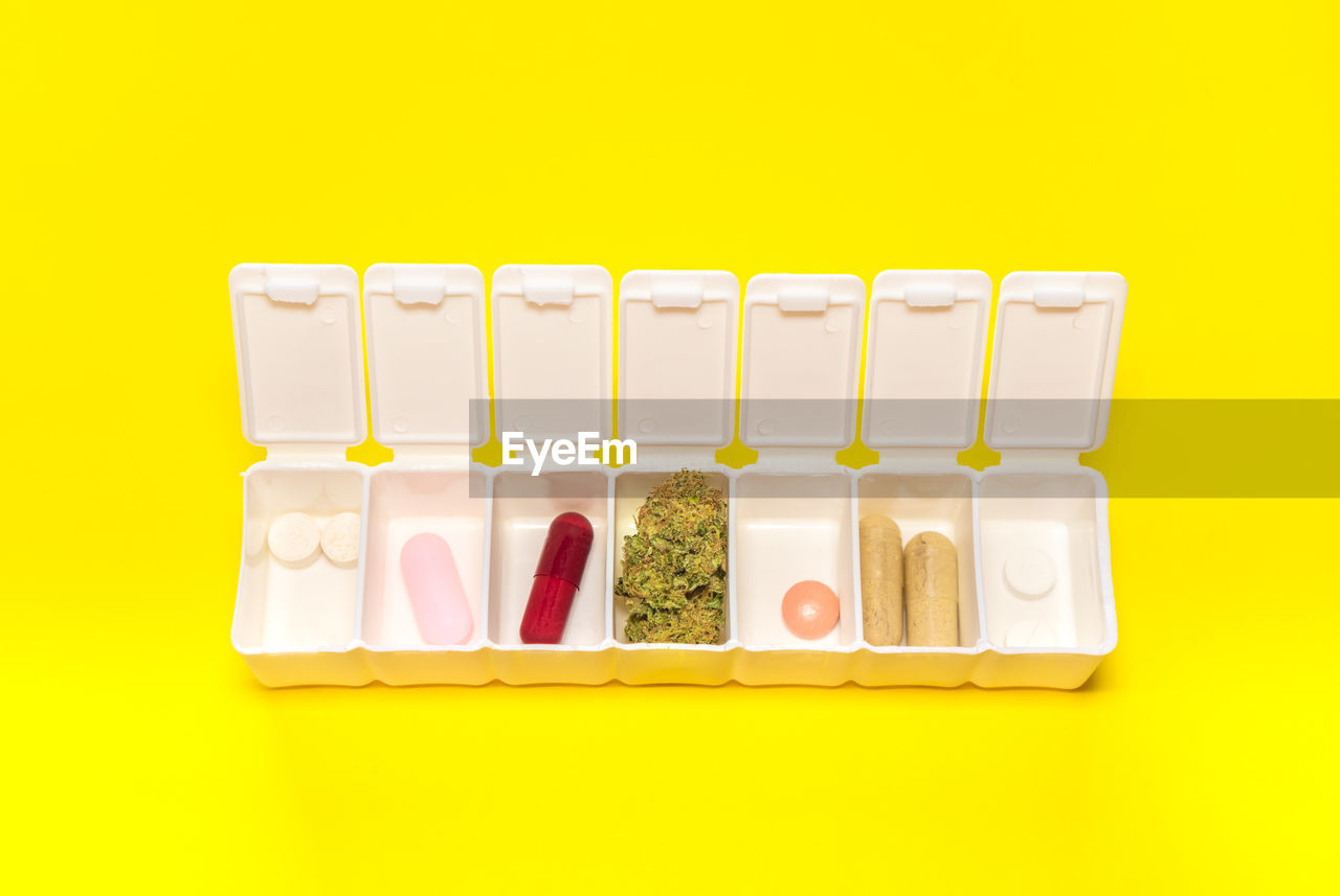 high angle view of pills against yellow wall