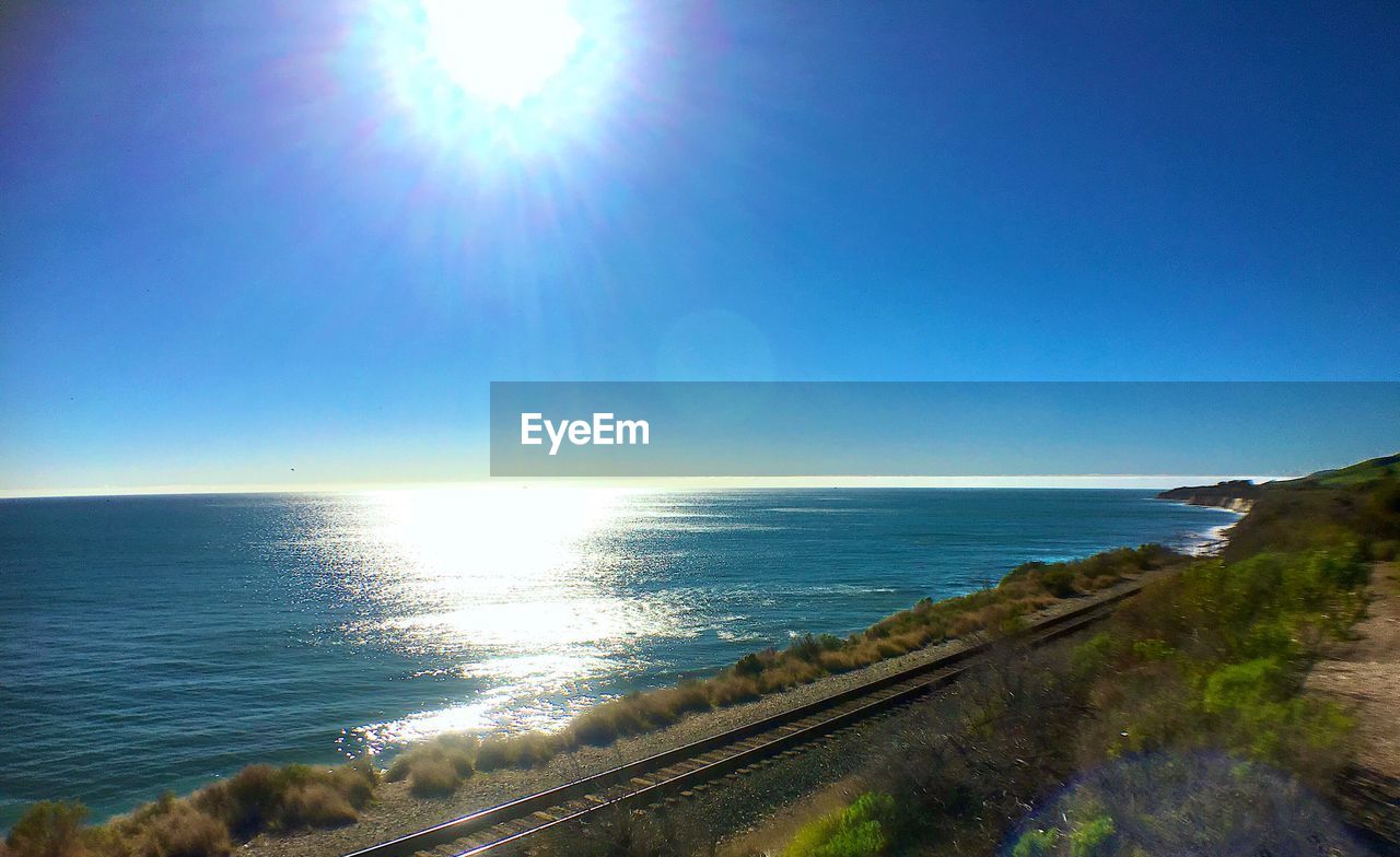 Scenic view of sea against bright blue sky