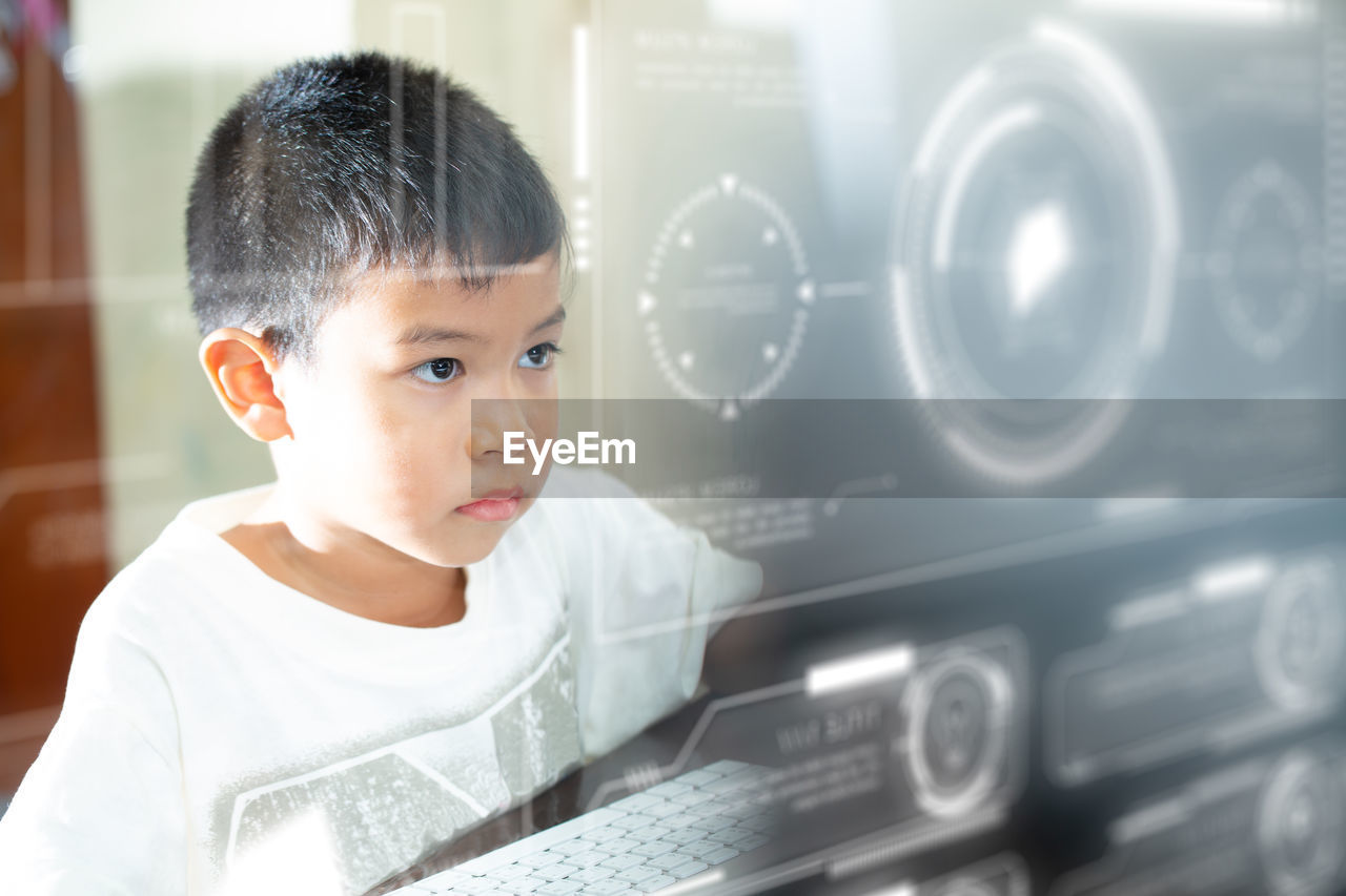 Digital composite image of boy looking at screen
