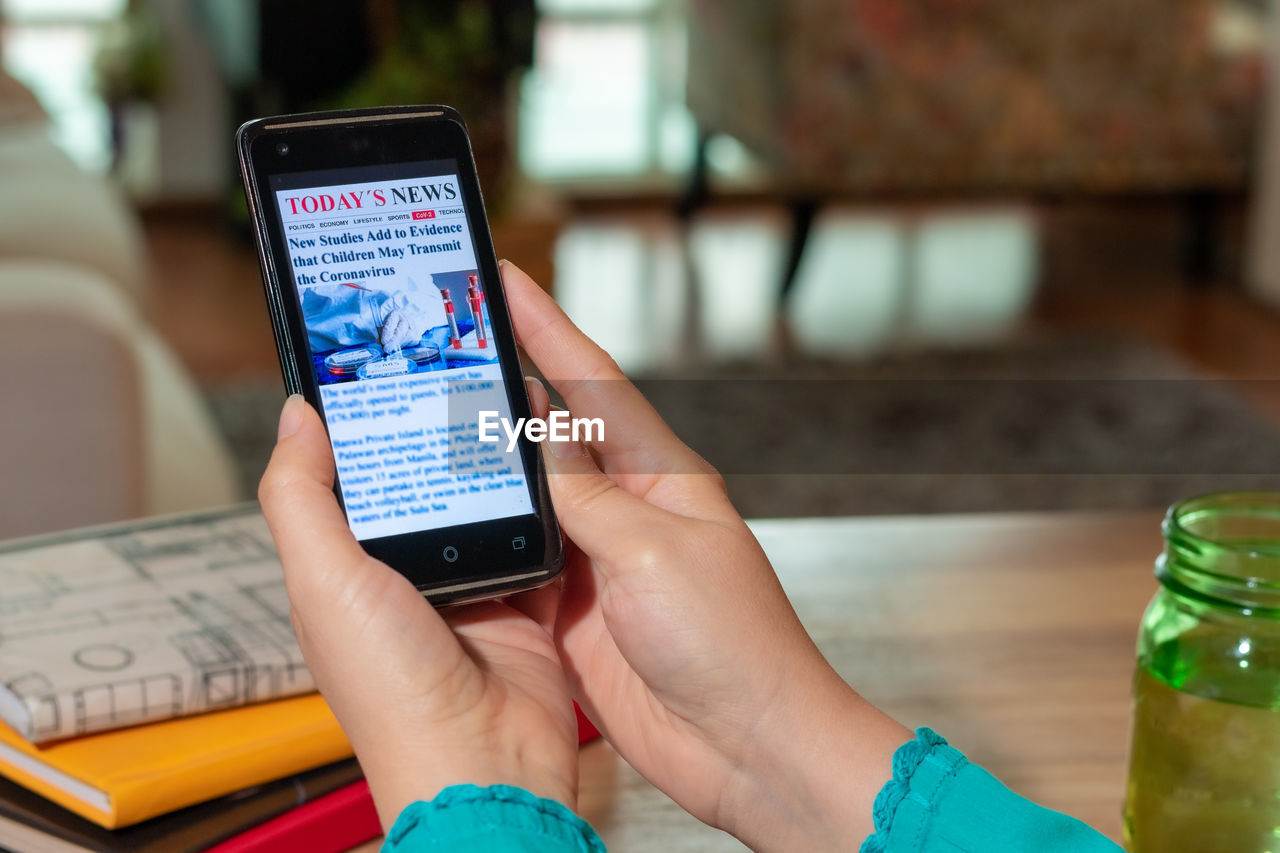 Woman reading coronavirus news on smart phone at home