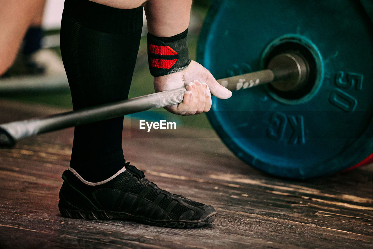 Close-up athlete and barbell exercise deadlift