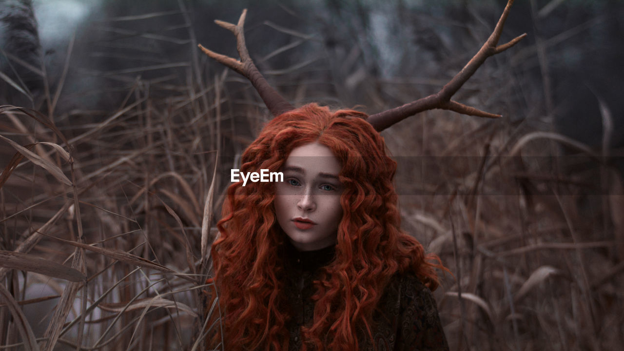 Portrait of young redhead woman in forest