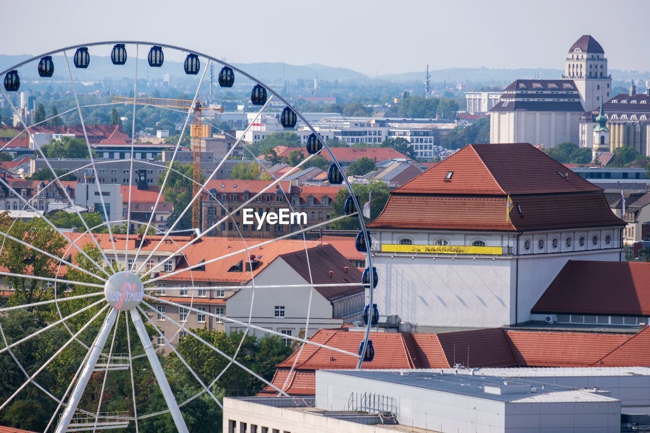 High angle view of ferris wheel against buildings in city