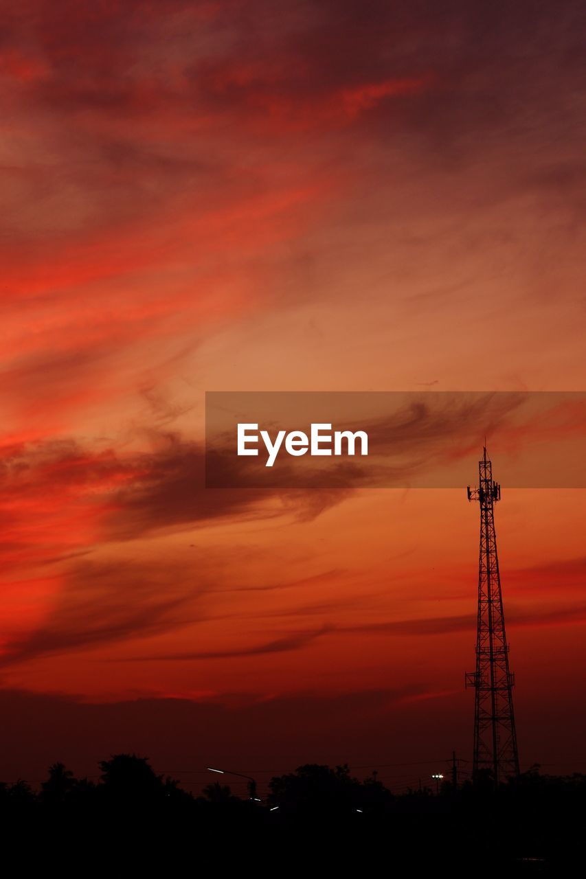 LOW ANGLE VIEW OF COMMUNICATIONS TOWER AGAINST SKY DURING SUNSET