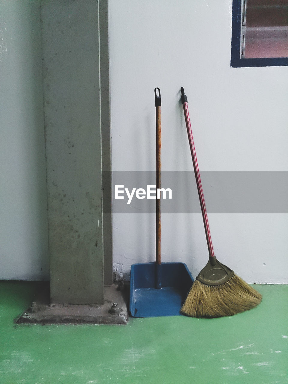 Broom with dust pan by wall