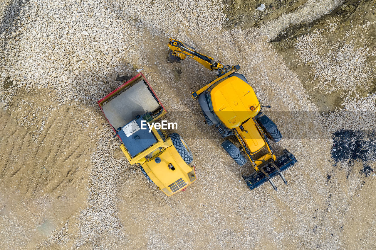 HIGH ANGLE VIEW OF YELLOW CONSTRUCTION SITE ON SAND