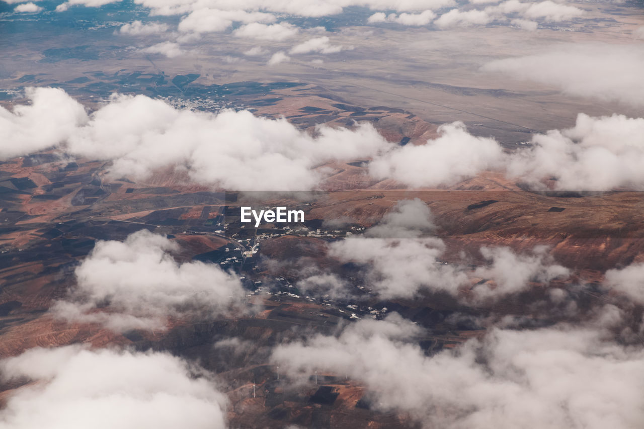 AERIAL VIEW OF CLOUDS OVER MOUNTAINS