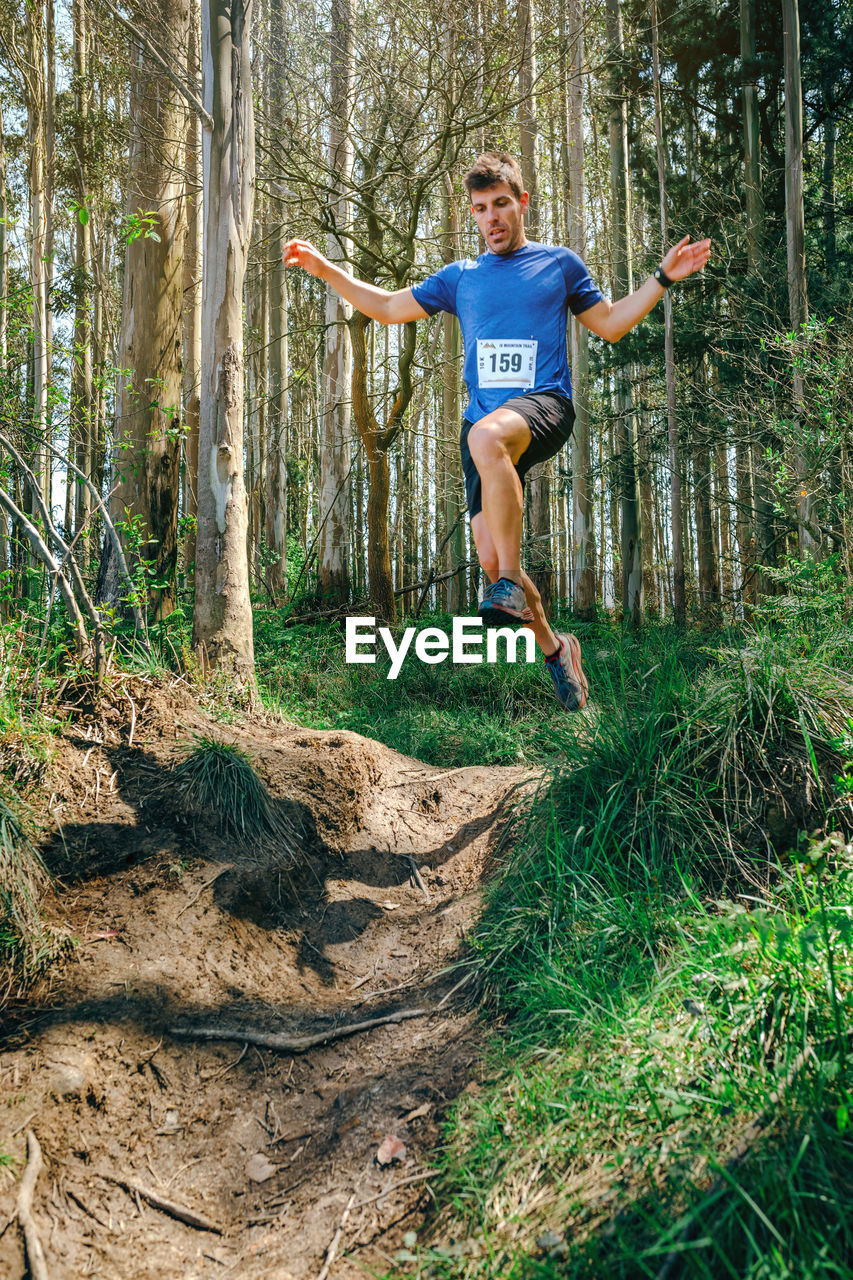 Full length of man jumping in forest