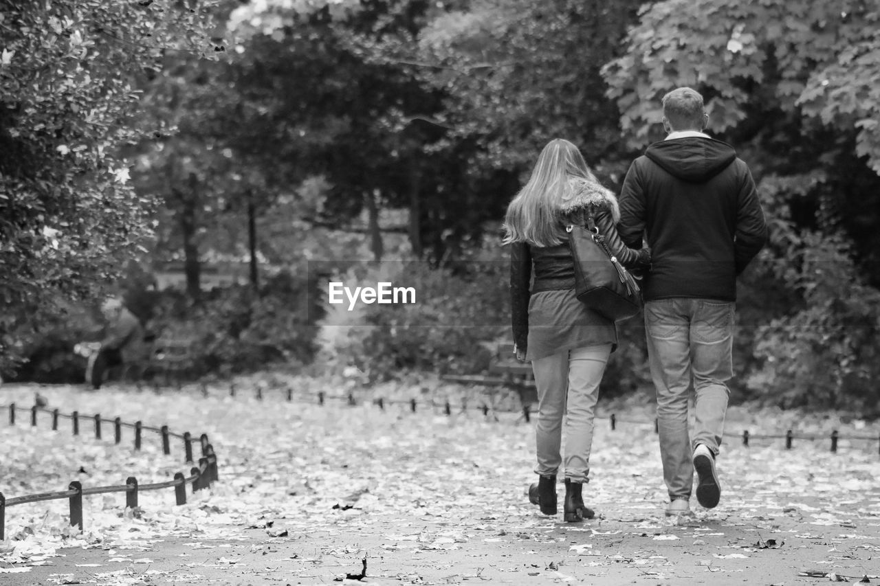 Full length rear view of man and woman walking at st stephen green