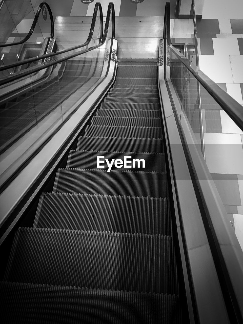 HIGH ANGLE VIEW OF ESCALATOR IN EMPTY STAIRCASE
