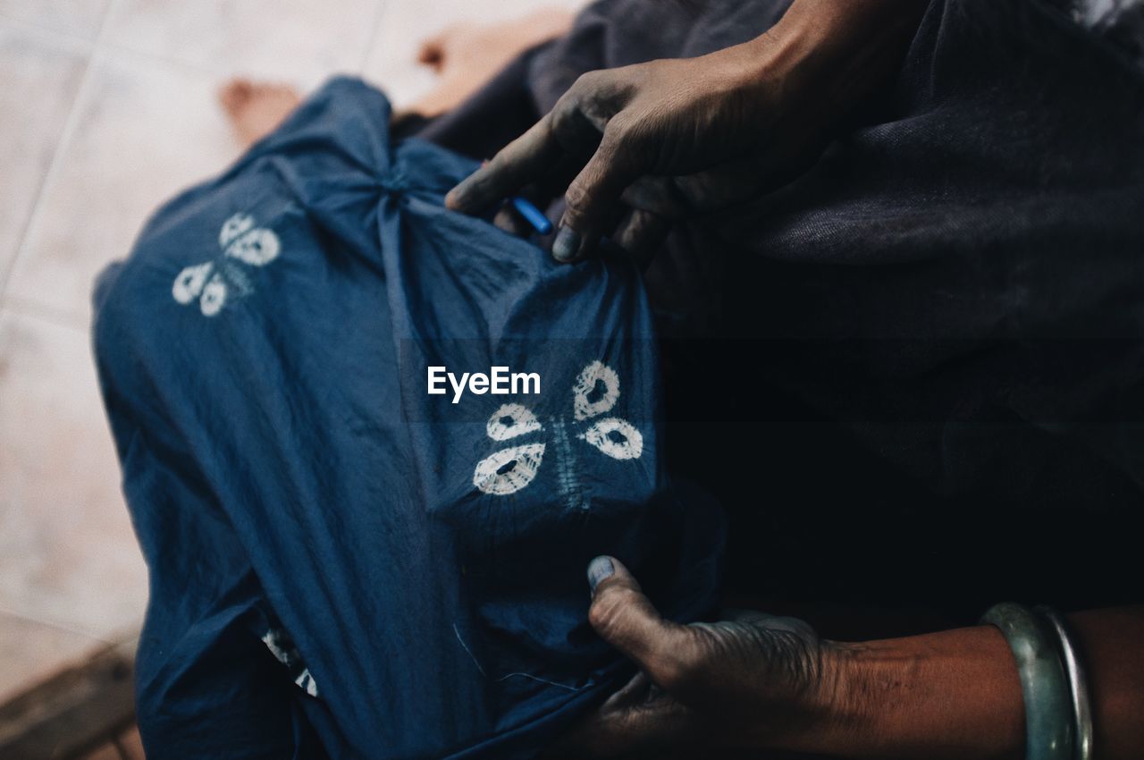 Midsection of person holding fabric