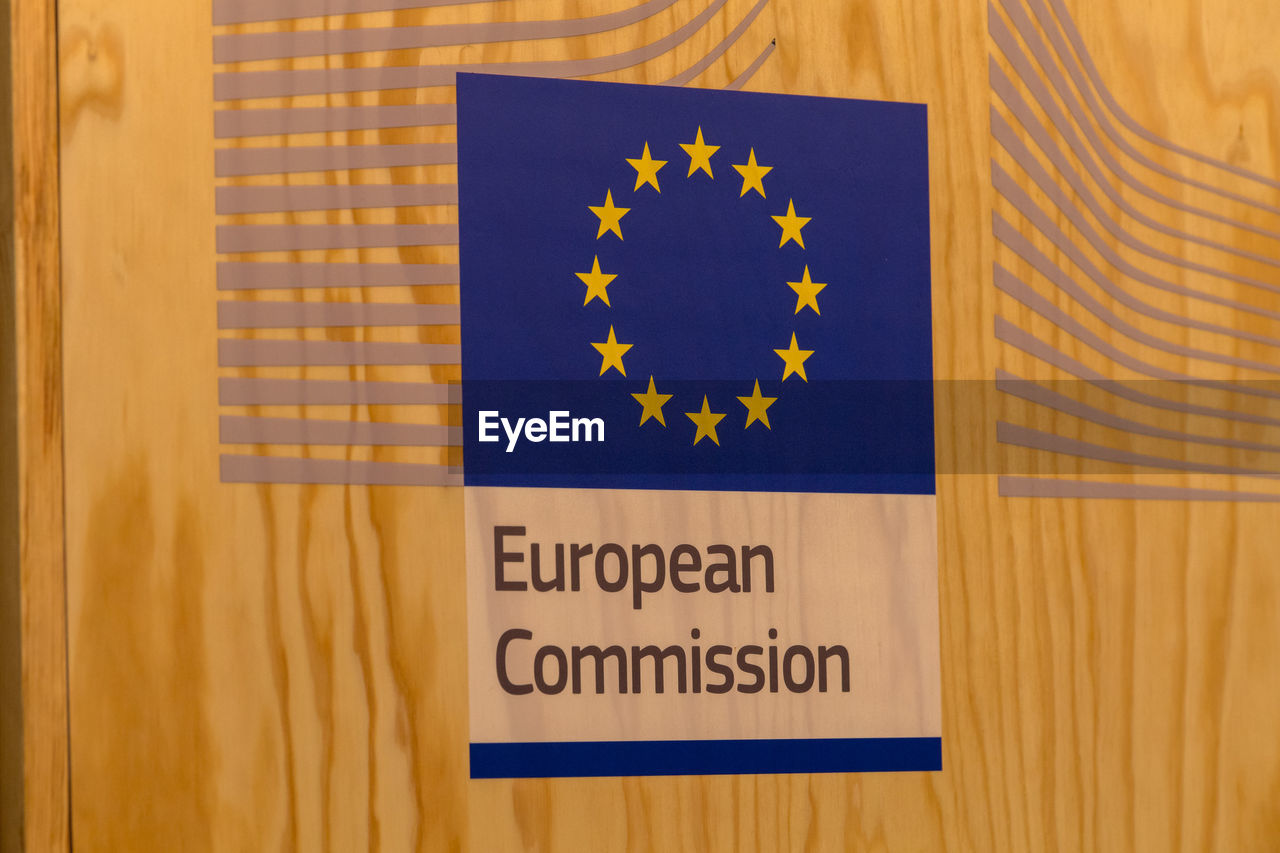 Close-up of european commission sign on wooden wall