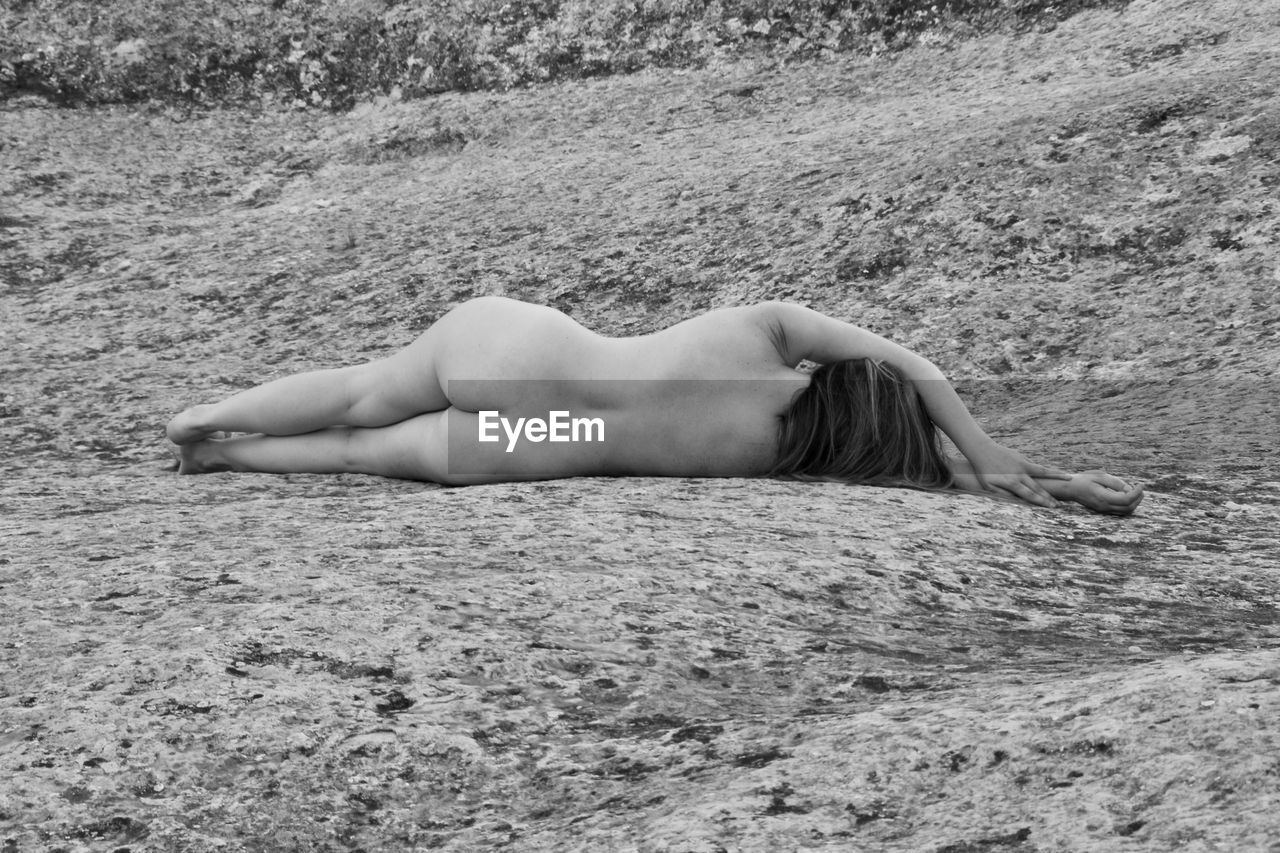 Midsection of woman resting on sand at beach