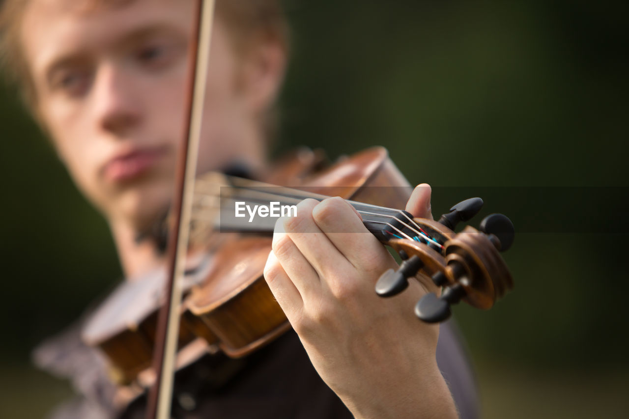Close-up of man playing violin